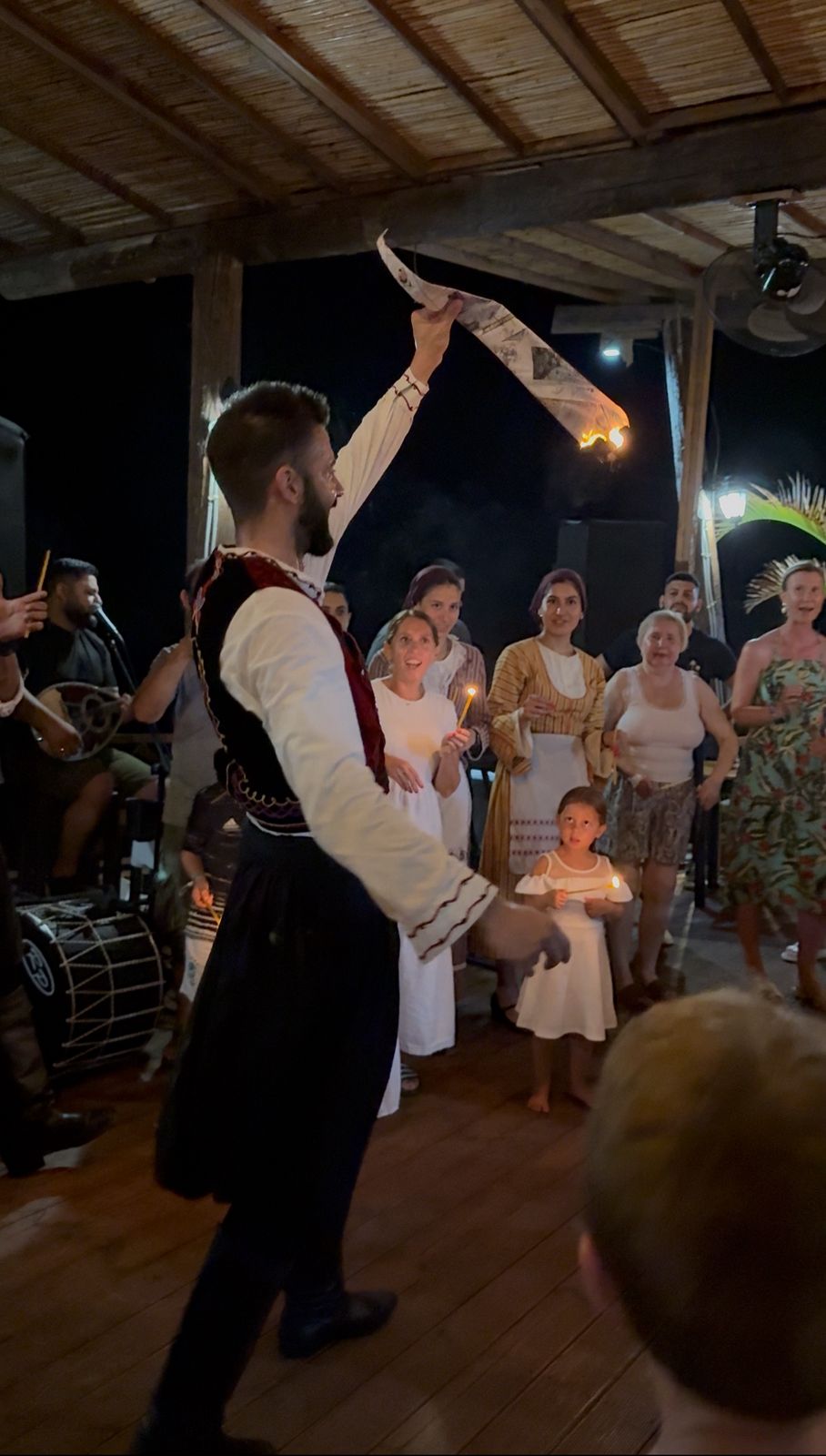 Traditional Greek dancer performing among guests