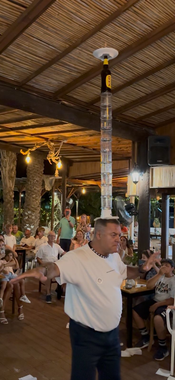 A performer balancing glasses at Greek Night