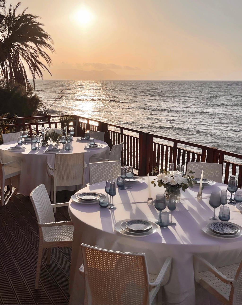 Sea-facing tables on the Pas To Kima terrace at sunset